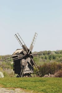 Traditional windmill on field against clear sky