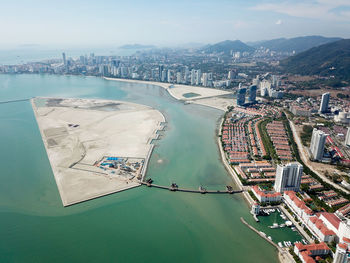 High angle view of city by sea against sky