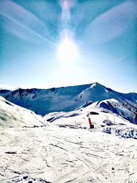 Scenic view of snowcapped mountains against sky on sunny day