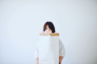 Portrait of woman standing against white background