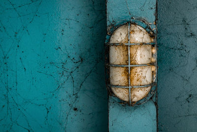 Close-up of abandoned light against wall