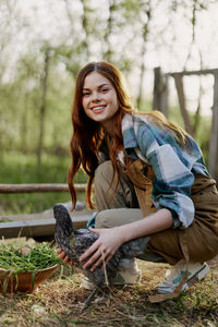 Portrait of smiling young woman sitting on field