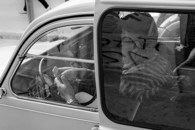 Reflection of man on side-view mirror