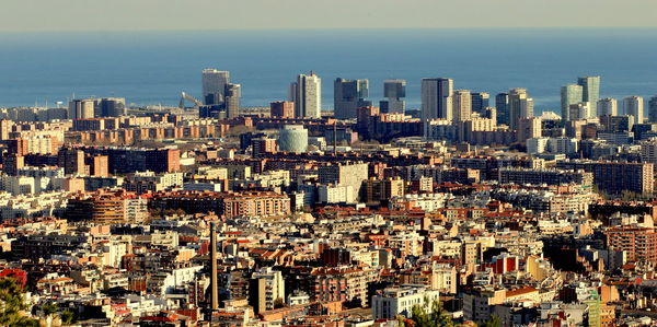 Aerial view of buildings in city against sky