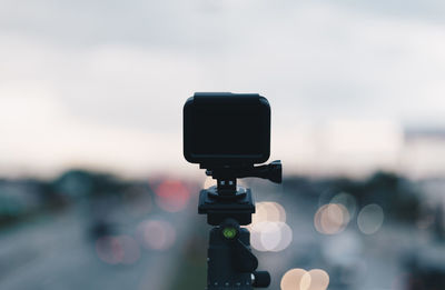 Close-up of camera photographing against sky