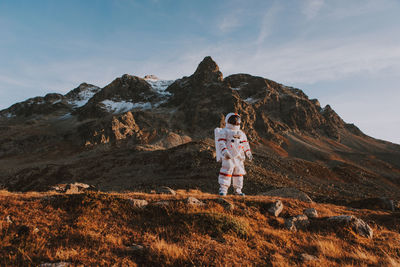 Full length of man standing on rock against sky