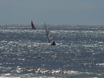 Boat sailing in sea against clear sky