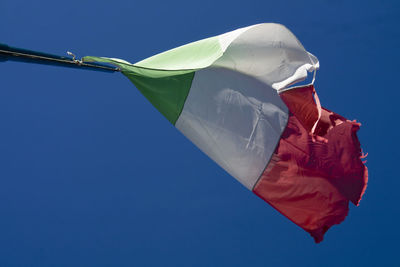 Low angle view of flag against clear blue sky