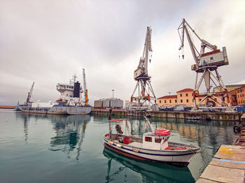 Italy, commercial port of imperia with fishing boats and ancient port cranes, liguria