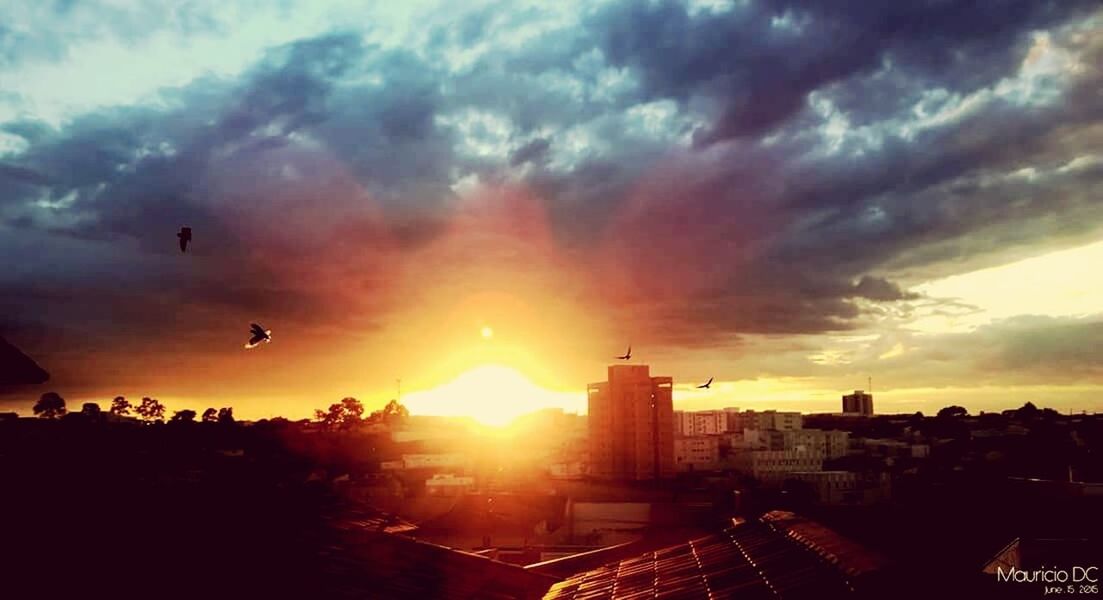 sunset, sun, building exterior, architecture, sky, cloud - sky, built structure, city, cityscape, sunbeam, silhouette, sunlight, orange color, cloudy, cloud, lens flare, beauty in nature, urban skyline, scenics, skyscraper