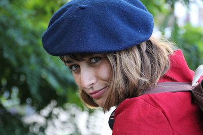 Portrait of woman wearing flat cap against plants