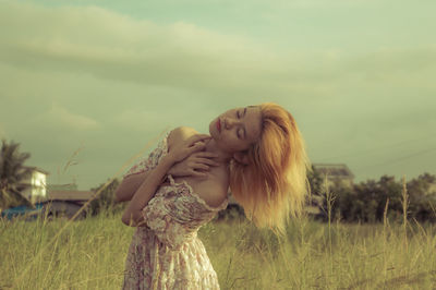 Woman standing on field against sky