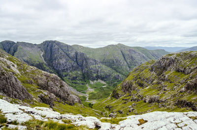 Scenic view of rocky mountains against cloudy sky