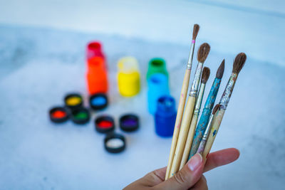 Close-up of hand holding colored pencils