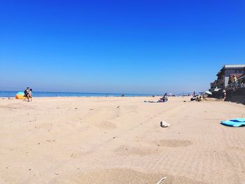 Scenic view of beach against clear blue sky