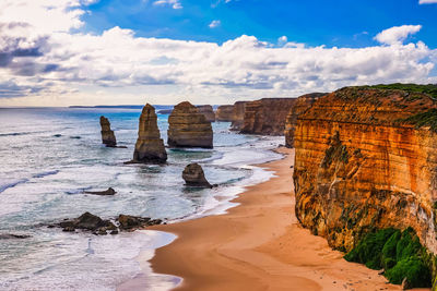 Rock formations on beach against sky