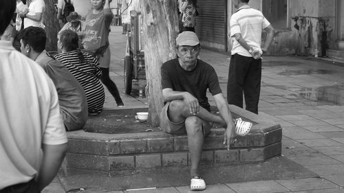 Rear view of people sitting on street