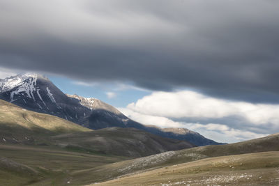 Scenic view of mountains against cloudy sky