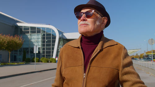 Portrait of man wearing sunglasses standing against sky