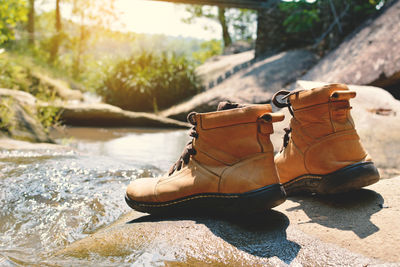 Close-up of shoes on rock by river