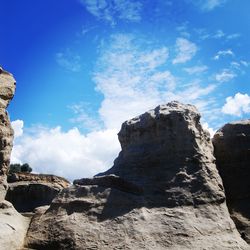 Rock formations against cloudy sky