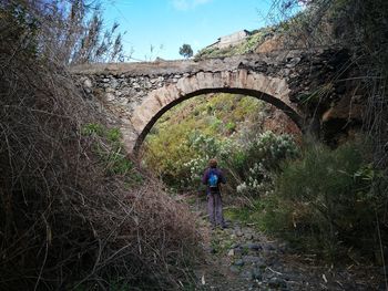 Person walking on arch bridge