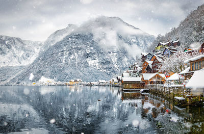 Scenic view of frozen lake by mountains against sky