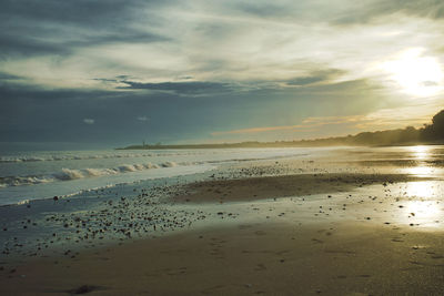 Scenic view of beach against sky during sunset