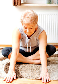 Senior woman stretching at home
