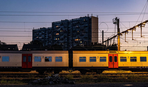 Train on railroad tracks in city against sky