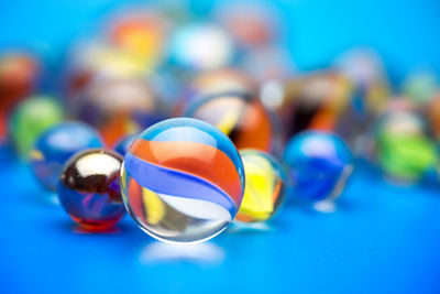 Close-up of multi colored marbles on blue table