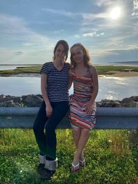 Full length of woman standing on shore against sky