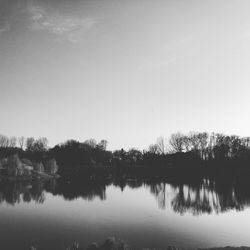 Reflection of trees in lake against clear sky