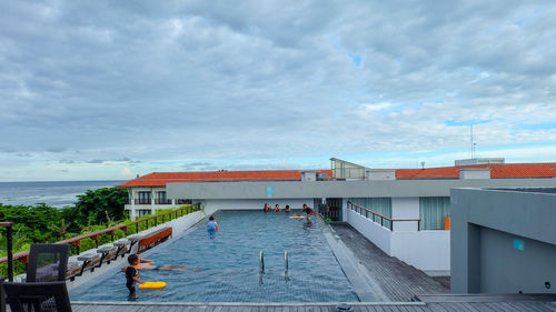 Buildings by swimming pool against sky