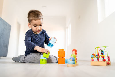 Cute boy playing with toys at home