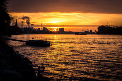 Silhouette of boat sailing in sea during sunset