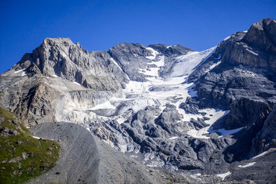 Scenic view of snowcapped mountains against clear blue sky