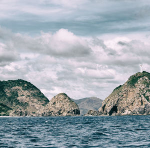 Scenic view of sea and mountains against sky