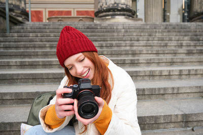 Young woman photographing with camera