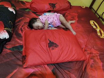 High angle view of girl sleeping on bed