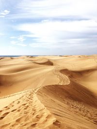 Sand dunes in desert against sky