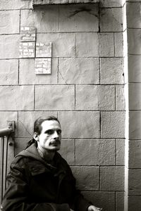 Portrait of man standing against wall
