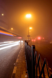 Light trails on city street against sky at night