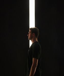 Man standing against black background