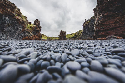 Surface level of rocks on beach against sky