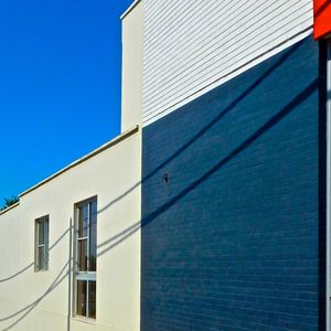 Low angle view of buildings against clear blue sky