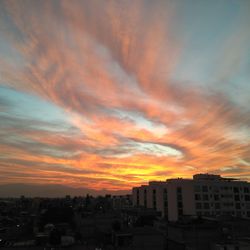 Silhouette buildings against sky during sunset