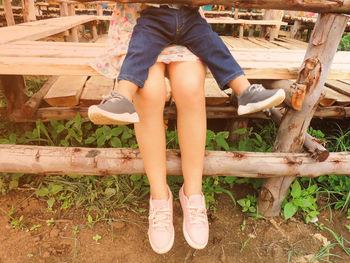 Low section of woman sitting on bench