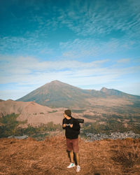 Rear view of man standing on mountain road