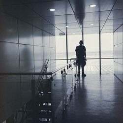 Rear view of silhouette man walking at airport